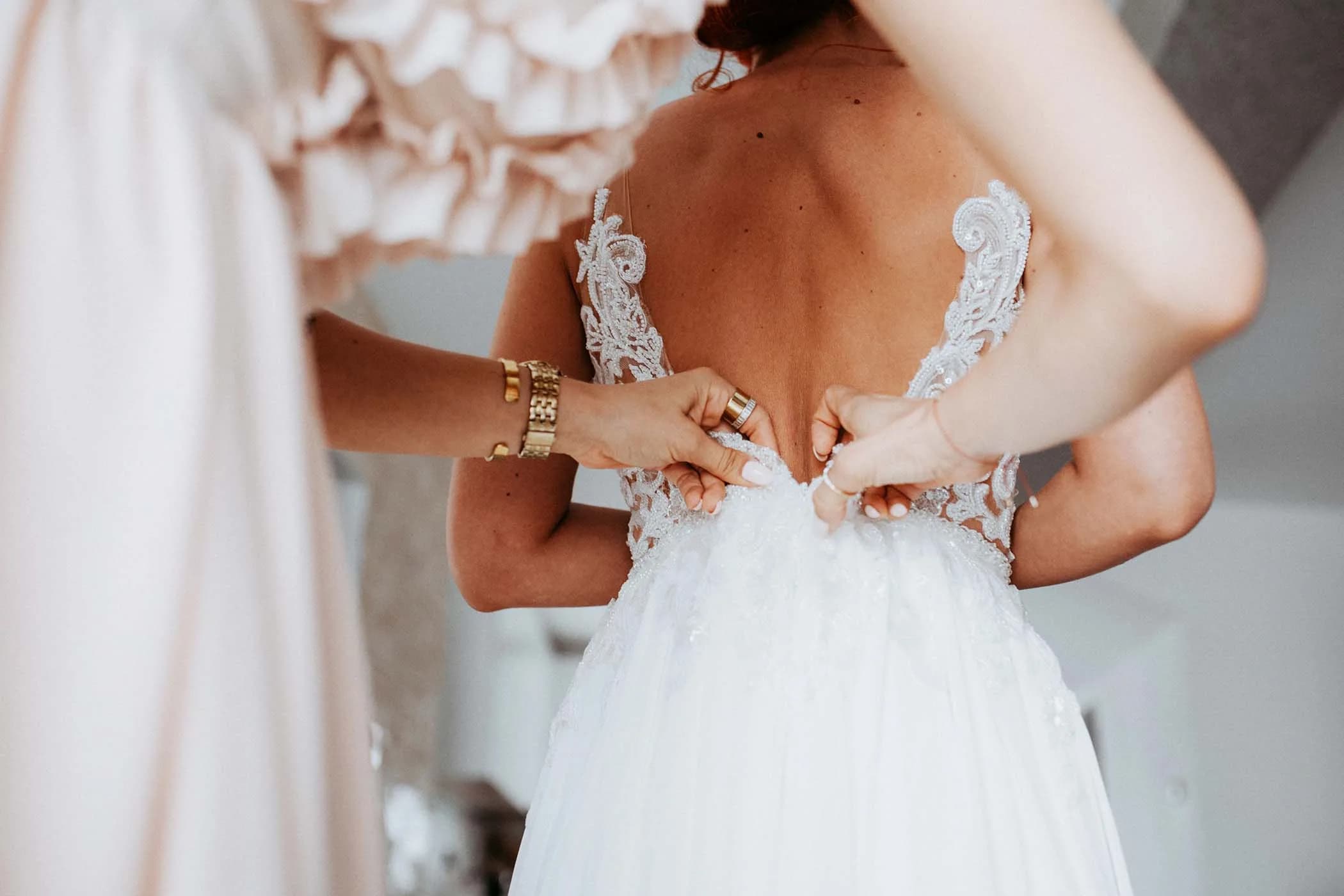 Fastening the wedding dress before a ceremony at Legends Event Center